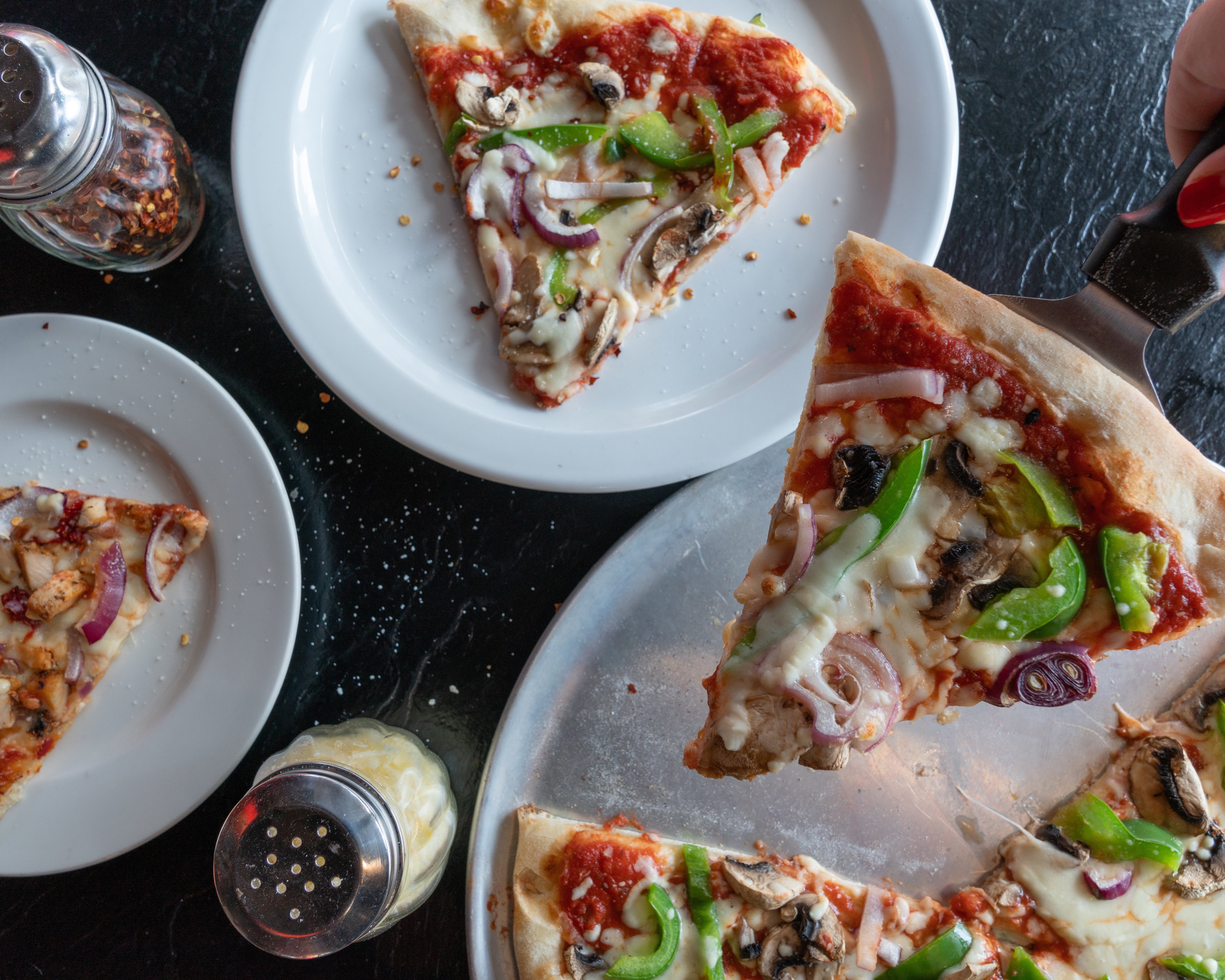 1775587885delux-pizza-slices-being-served.jpg